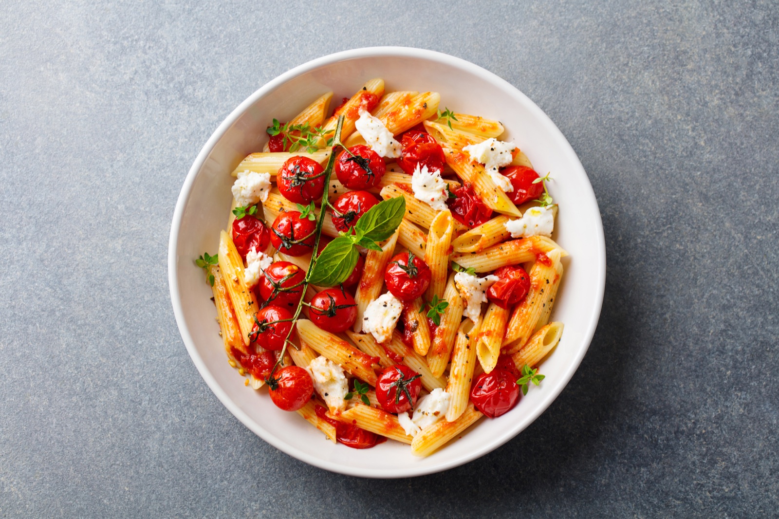 Penne with roasted tomatoes, soft cheese and fresh herbs